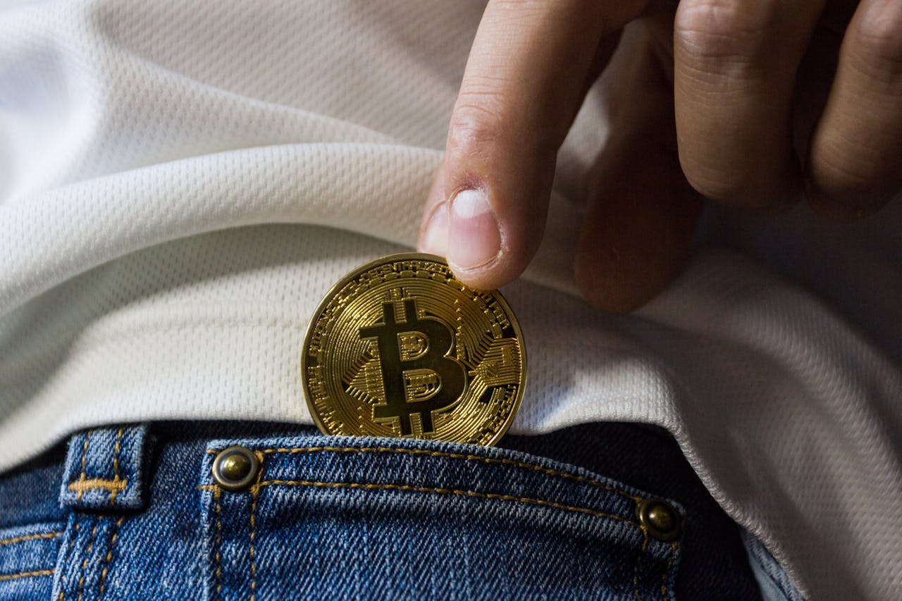 person putting bitcoin in back pocket