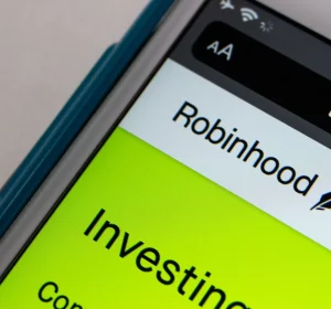 Close-up of a smartphone screen displaying the Robinhood website and investing interface.