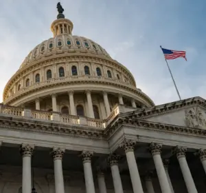 Low-angle view of the U.S. Capitol building with an American flag flying nearby