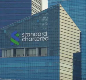 Standard Chartered logo displayed on the glass exterior of a modern office building