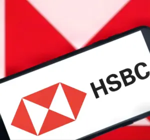 Smartphone displaying the HSBC logo in front of a large red and white HSBC branding background.