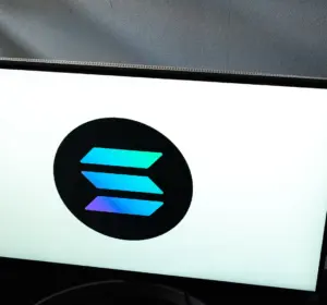 Solana logo displayed on a computer monitor in a dark room